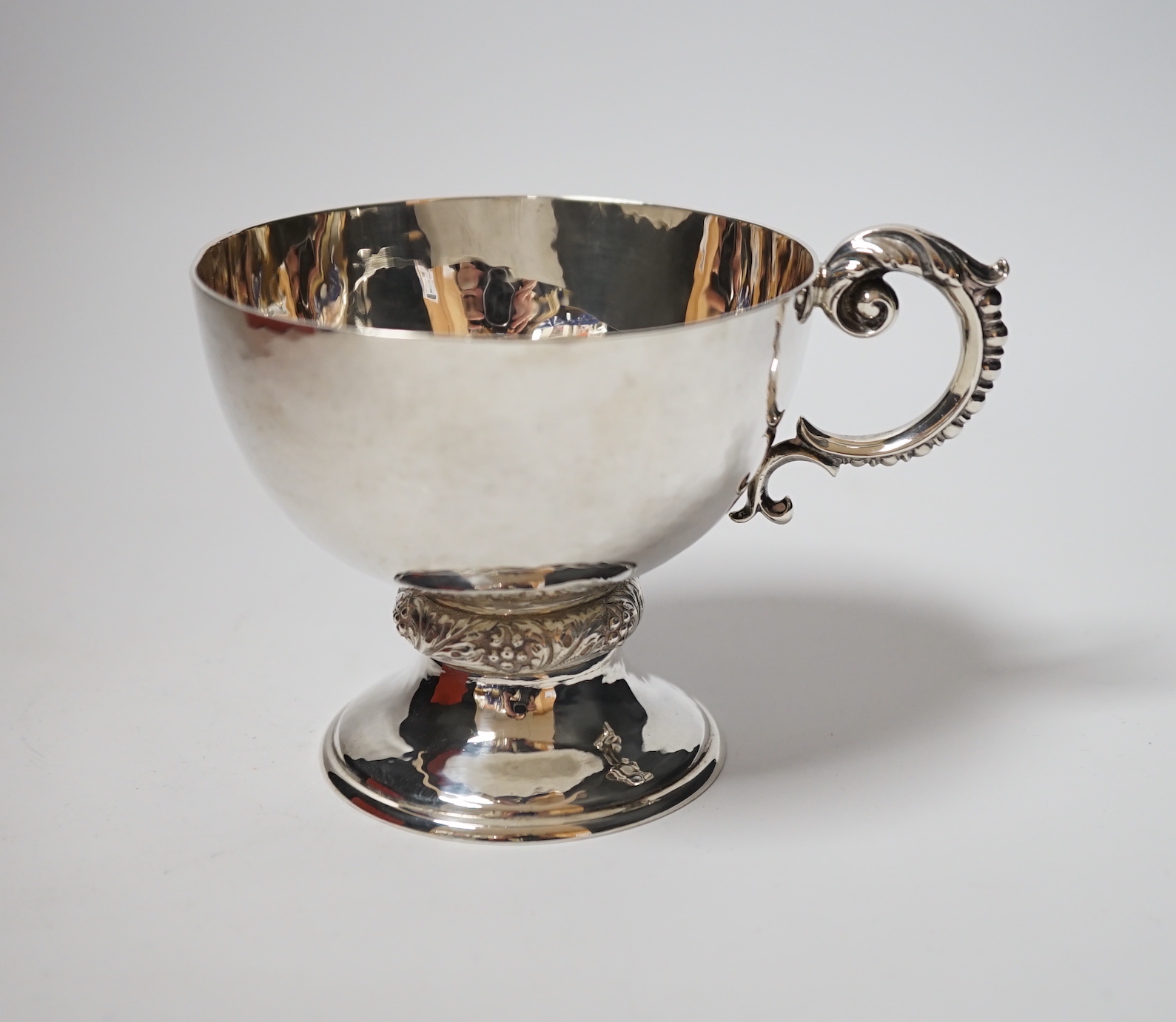A George V planished silver pedestal single handled cup, Goldsmiths & Silversmiths Co Ltd, London, 1926, 86mm, 5.9oz.
